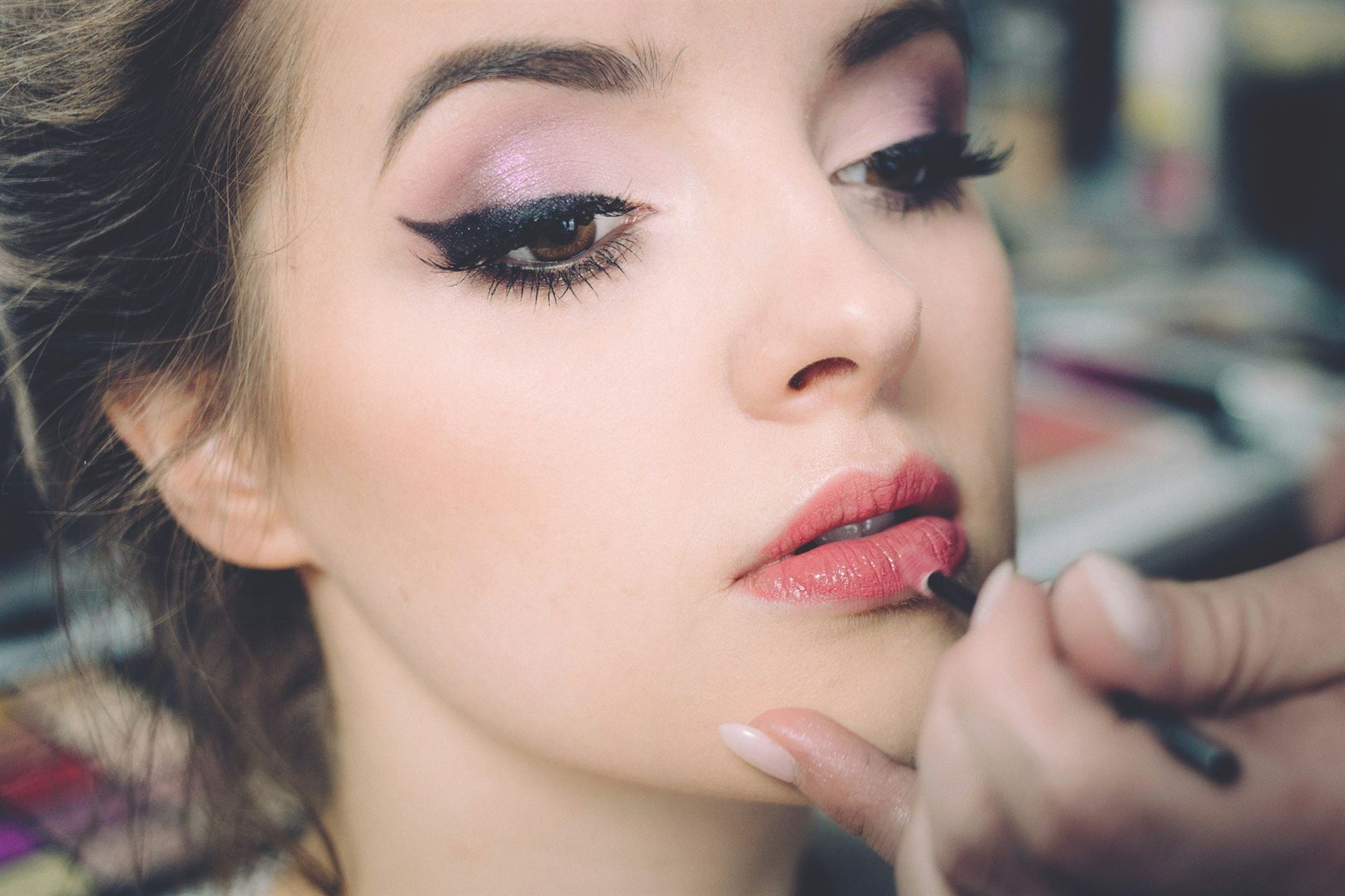 Makeup artist applying lipstick to a model